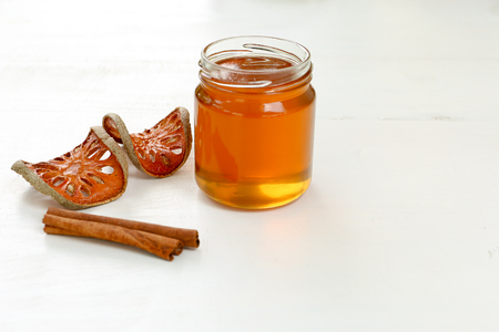 Honey with cinnamon and bael fruit on white background with copy spaceの写真素材