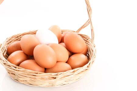 Eggs in a wooden basket in white backgroundの写真素材
