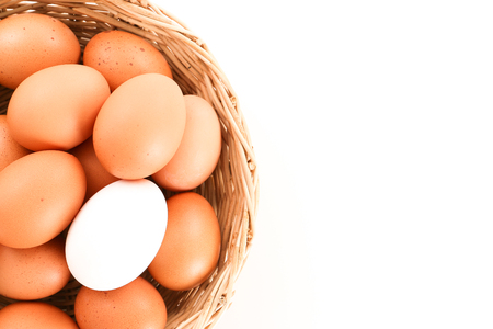 Eggs in a wooden basket in white background - top view with copy spaceの写真素材