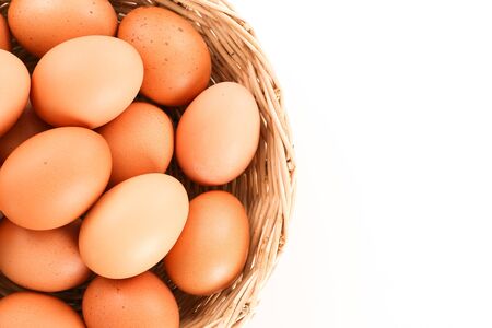 Eggs in a wooden basket in white background - top view with copy spaceの写真素材