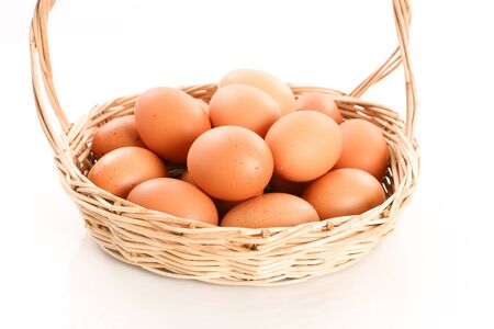 Eggs in a wooden basket on white backgroundの写真素材