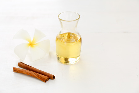 Oil with cinnamon and Plumeria on white background with copy spaceの写真素材