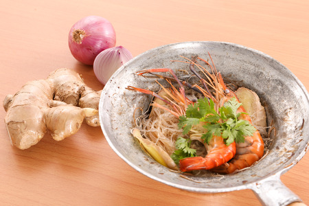 Thai baked shrimp with glass noodle in wood background - top viewの写真素材
