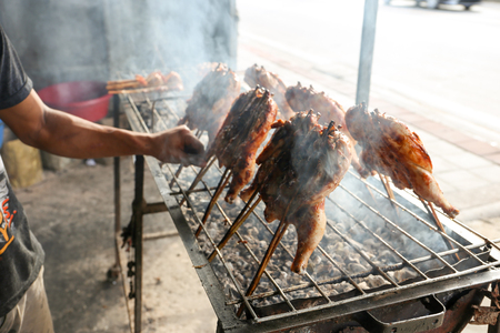 A local seller preparing Thai style roasted chicken, Thailand street foodの写真素材