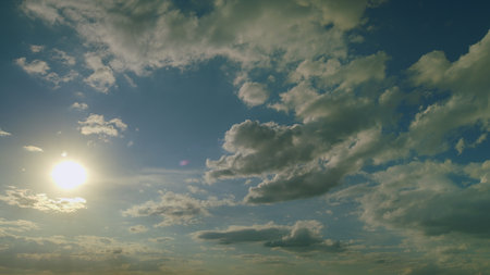 The beautiful sky filled with fluffy clouds and radiant sunlight glowing through itの写真素材