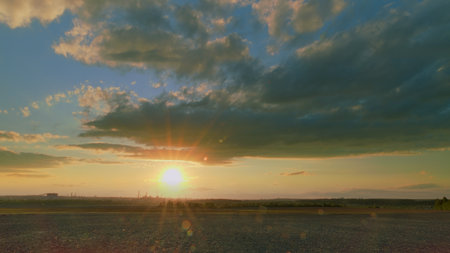 A Breathtaking Stunning Sunset Over a Serene Landscape Surrounded by Colorful Beautiful Skiesの写真素材