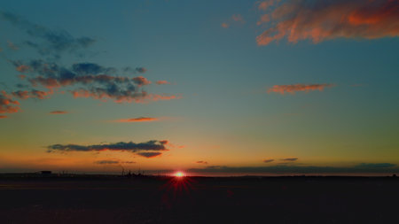 Experience the breathtaking sunset over a serene landscape that captivates the soulの写真素材