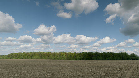 Serene Landscape Featuring Beautiful Clouds Over Lush Fields and Rolling Countrysideの写真素材