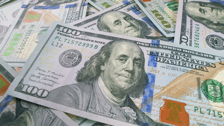 There are stacks of U.S. Hundred Dollar Bills neatly arranged on a Table in front of youの写真素材