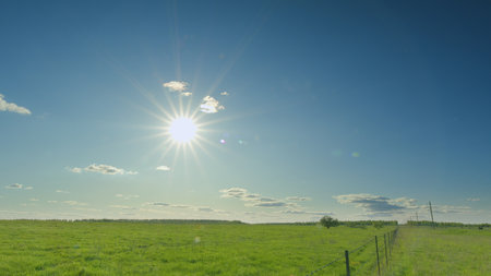A vibrant and sunny day is unfolding over the lush green fields, creating a beautiful scene Time lapse.の写真素材