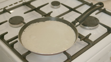 Deliciously Cooking Pancakes on a Gas Stove Using a Frying Pan for Breakfast or Snacksの写真素材