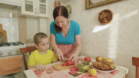 A Mother and Her Child Enjoy Cooking Together in a Bright and Cheerful Kitchen Settingの写真素材