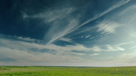 A Serene and Beautiful Landscape featuring an Expansive Sky Alongside Vibrant Greeneryの写真素材
