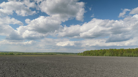 A Beautiful and Serene Landscape Showcasing Dramatic Clouds Hovering Over a Fieldの写真素材