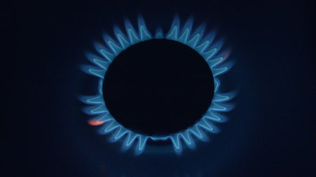 An Illuminating Gas Flame Featuring Striking Blue Flames Set Against a Dark Backgroundの写真素材