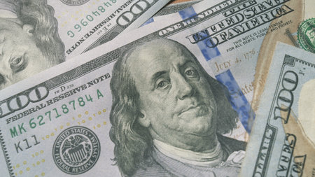 A detailed closeup view of several American Dollar Bills intricately piled together in a stackの写真素材