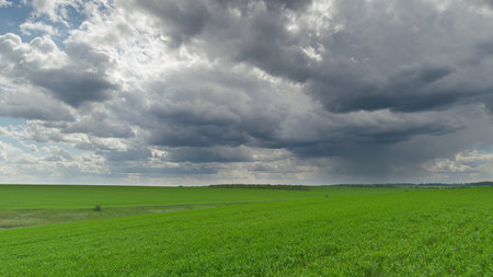 Dramatic Skies Above Lush Green Fields A Truly Stunning and Beautiful Natures Canvas Time lapse.の写真素材