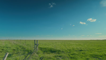 A Vast Green Landscape Spreading Under a Clear and Blue Sky Time lapse.の写真素材