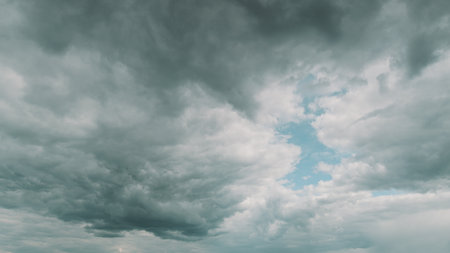 A stunning dramatic cloudscape featuring a vivid blue sky peeking through the clouds Time lapse.の写真素材