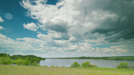 A beautiful and serene lakeside landscape featuring dramatic clouds in the sky above Time lapse.の写真素材