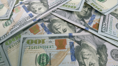 A Neatly Arranged Stack of Hundred Dollar Bills Placed on a Flat Surface for Displayの写真素材