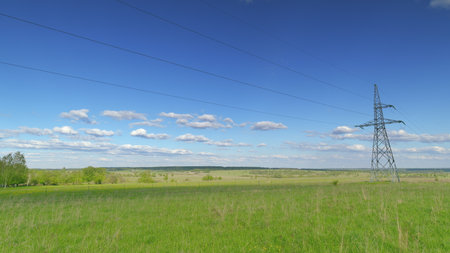 Vast and Expansive Green Landscape Featuring Power Lines Beneath a Clear and Blue Sky Time lapse.の写真素材