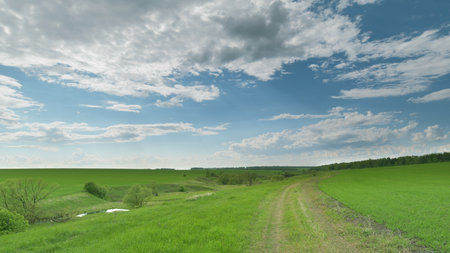 Serene and picturesque Green Hills with a clear Sky and a winding Pathway inviting exploration Time lapse.の写真素材