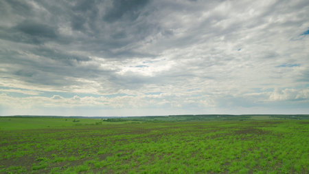 The Expansive Green Fields Stretching Beneath a Dramatic and Majestic Cloudy Sky Time lapse.