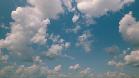 Time lapse. A Clear Sky adorned with Fluffy Clouds creates a Beautiful Scenic Blue Backgroundの写真素材