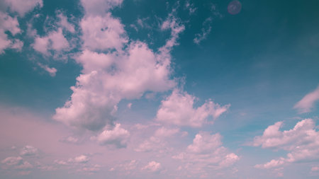 Time lapse. A Beautiful Sky Showcasing Fluffy White Clouds Set Against a Soft and Calm Blue Backgroundの写真素材