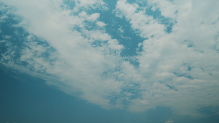 Time lapse. Serene Sky Gradients and Soft Fluffy Clouds Floating Overhead During Daytime Hoursの写真素材