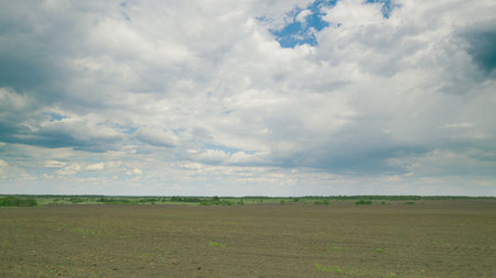 Vast Fields Stretching Under a Beautiful Cloudy Sky A Truly Serene and Breathtaking Landscape Time lapse.の写真素材