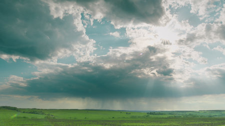 A Stunning and Dramatic Sky Over Vibrant Green Fields Accompanied by Gentle Rain Showers Time lapse.