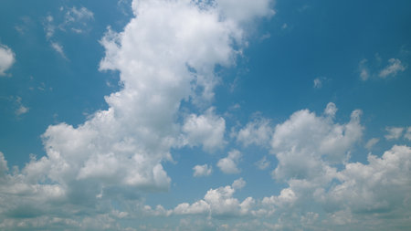 Time lapse. A Beautiful and Calming Cloudy Sky Can Be Seen Overhead with a Vibrant Blue Backgroundの写真素材