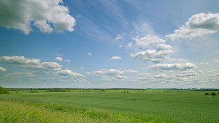 Time lapse. A Beautiful Scenic Landscape Featuring Lush Green Fields Beneath a Vibrant Blue Skyの写真素材