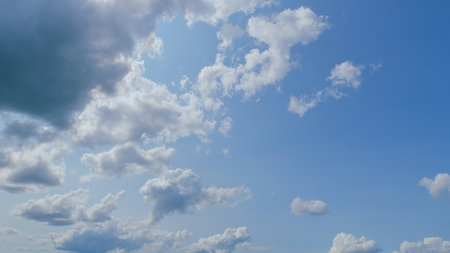 A Stunningly Beautiful Sky Filled with Fluffy Clouds Against a Bright and Clear Blue Backgroundの写真素材