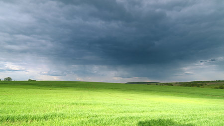 A Dramatic and Beautiful Cloudy Sky Over Lush Green Fields Creates a Captivating Scene Time lapse.の写真素材