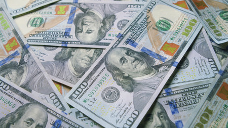 A large pile of currency featuring hundred dollar bills showcasing financial wealth and assetsの写真素材