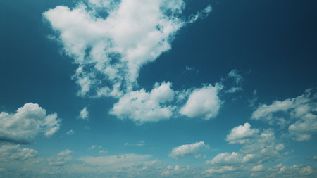 Time lapse. A beautiful and vibrant blue sky adorned with fluffy and picturesque clouds above usの写真素材