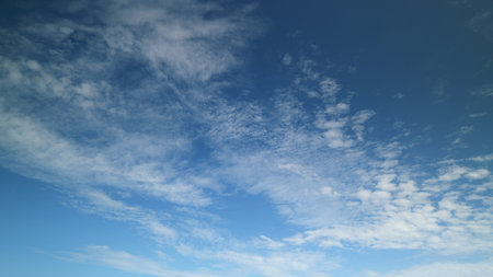 Time lapse. Stunningly Beautiful Cloud Patterns Set Against a Clear and Bright Blue Sky Above Usの写真素材