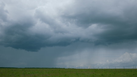 A Dramatic Cloudy Sky Looms Over Vibrant Green Fields, Creating a Stunning Visual Contrast