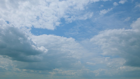 A beautiful scenic view of the sky, with fluffy clouds set against a bright blue backgroundの写真素材