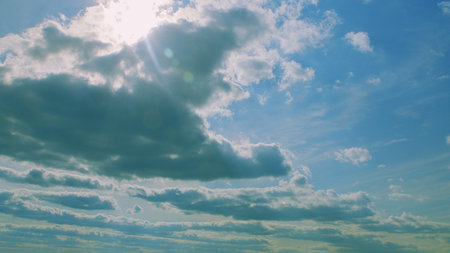 A Beautiful Serene Blue Sky Accompanied by Soft Clouds and Gentle Sunlight Shining Brightly