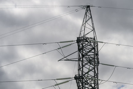 A High Voltage Power Transmission Tower Stands Tall Against a Dramatic and Beautiful Skyの写真素材