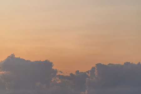 The Serene Sunset Casts Its Glow Over a Beautifully Cloudy Horizon, Creating a Tranquil Sceneの写真素材