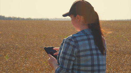 A dedicated farmer is utilizing a smartphone while working in the picturesque field today