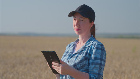 A Female Farmer Engaged in Analyzing Data Right in the Field of Agriculture and Nature