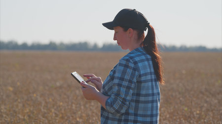 A woman uses a tablet in an agriculture field, improving efficiency in data management