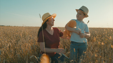 Experiencing Joyful Moments in the Beautiful Wheat Field Heartwarming Mother and Son Bondingの写真素材
