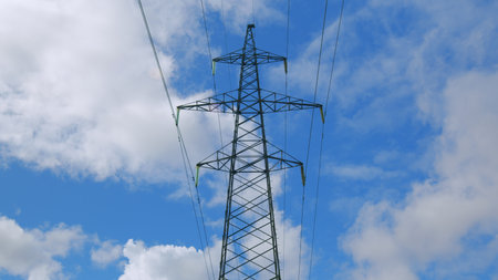 High voltage power line stretches across a clear blue sky, exemplifying modern infrastructure